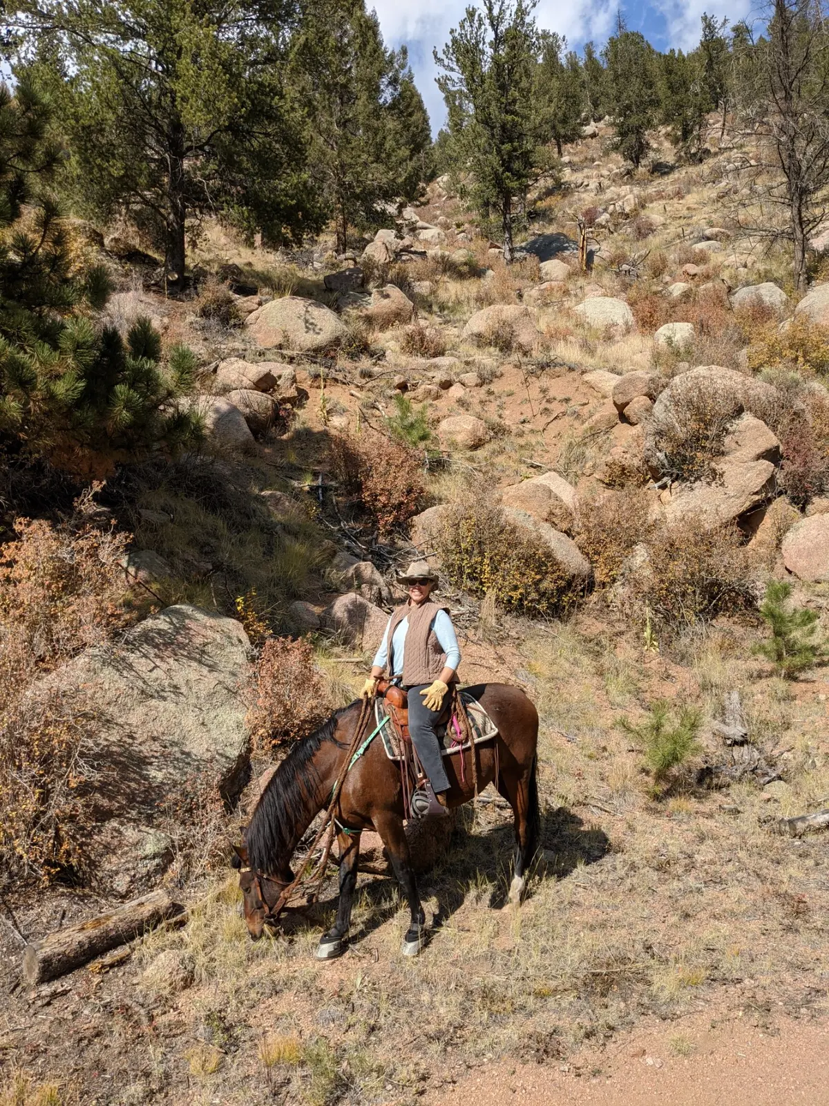 Riders making their way across rugged ranch land.