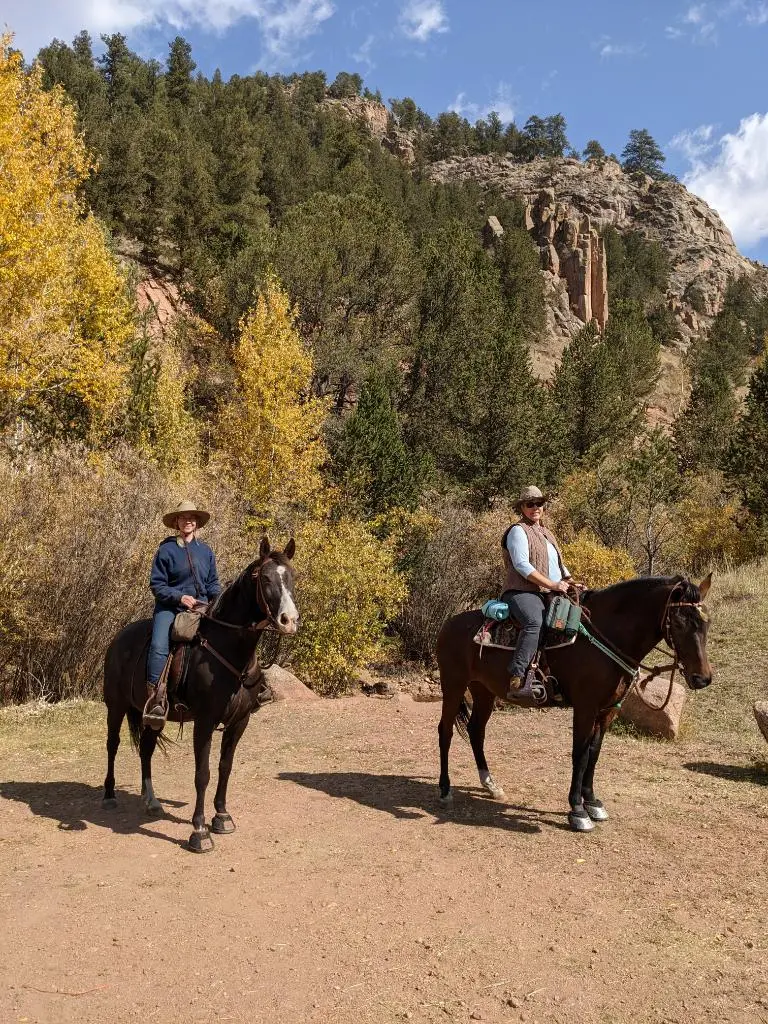 Two riders enjoying a fall ranch ride.