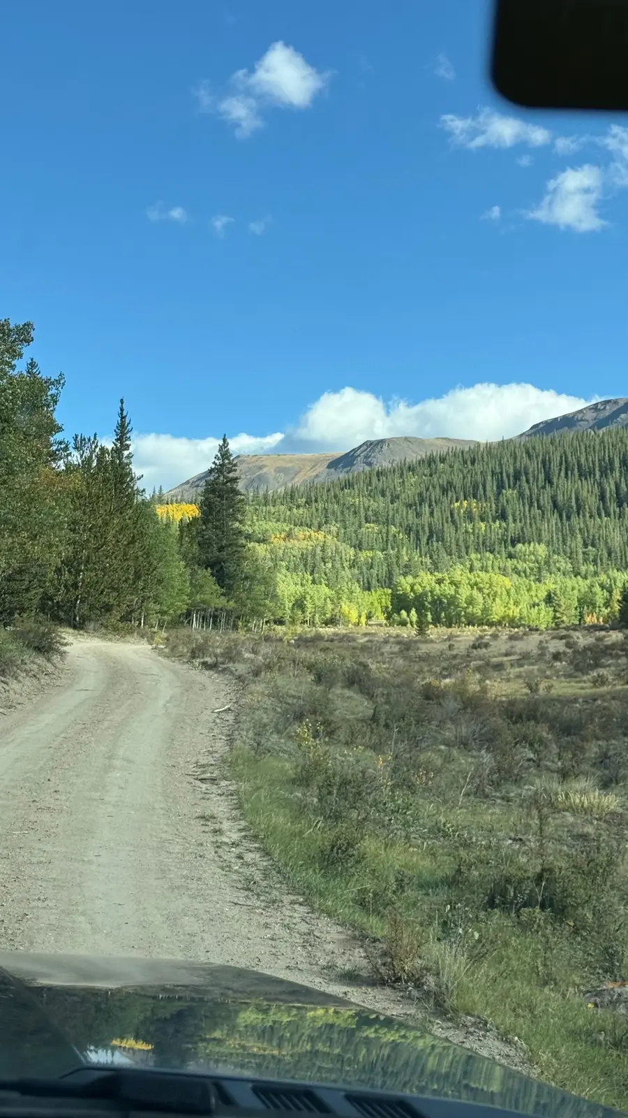 A back-country road winding toward the mountains.